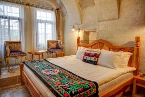 乌奇希萨尔Petra Inn Cappadocia的一间带一张大床的卧室,位于带窗户的房间内