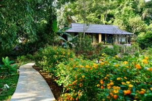木州县Moc Chau Retreat的通往鲜花房子的花园路径