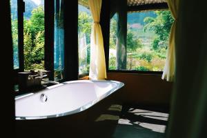 木州县Moc Chau Retreat的带浴缸的大窗户