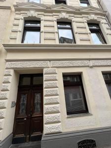 科隆Retro Appartement im Herzen von Köln Deutz的一座建筑,设有棕色的门和几扇窗户