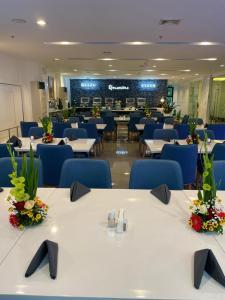 宿务Stacia Hotel powered by Cocotel的餐厅设有白色的桌子和蓝色的椅子