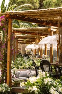 圣安东尼奥Parco Ibiza, by Camping San Antonio est 1961的一个带桌椅和鲜花的木制凉亭