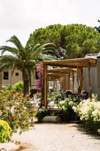 圣安东尼奥Parco Ibiza, by Camping San Antonio est 1961的一个带凉亭、棕榈树和鲜花的花园