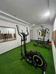 锡纳亚Vila Tequila Sinaia的一间设有绿色草地和健身器材的健身房