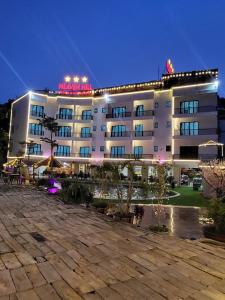 Cham Ta LaoHeaven Hill Hotel & Hot Spring的一座酒店大楼,晚上有庭院