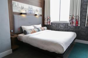 利物浦Aloft Liverpool的卧室配有一张带白色床单和枕头的大床。