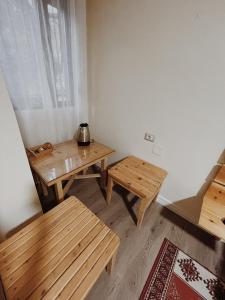 戈里察At Pikotiko's - Korca City Rooms for Rent的客房设有木桌、长凳和窗户。