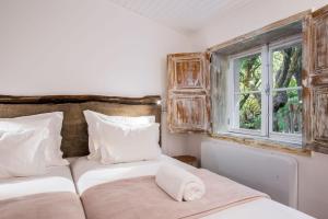伊斯特雷托达卡耶塔Rabaçal Nature Spot Cottage的一间卧室设有两张床和窗户。
