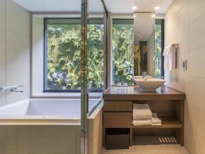 京都京都索拉利亚西铁尊贵酒店的带浴缸、水槽和窗户的浴室