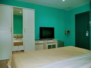 南芭堤雅Marine paradise Encore的一间卧室配有一张床和一台平面电视