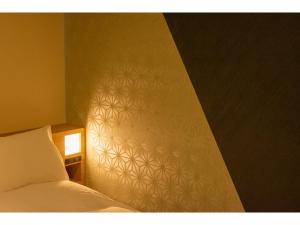 金泽金泽大酒店的一间卧室设有一张床和一面墙