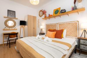 里斯本Serene 2BDR Apartment W/ Patio by LovelyStay的一间卧室配有一张带橙色枕头的大床