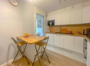 马赛LE BUNKER Prado Plage Velodrome的厨房配有白色橱柜和木桌
