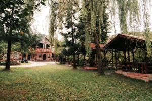 阿尔特温Lome Çiftliği Otel ve Restoran的长凳和树木的公园和建筑