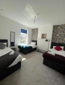 伍尔弗汉普顿Dukes Place sleeps 10 comfortably的一间卧室设有两张床、一张沙发和一个窗口