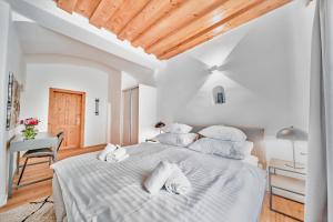 多瑙河畔克雷姆斯Smile Apartments "Lesehof"的白色卧室配有一张带白色枕头的大床