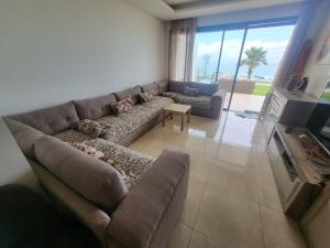 西迪布克纳德尔Appartement Plage des Nations Prestigia Front Mer avec grand Jardin的客厅配有沙发和桌子