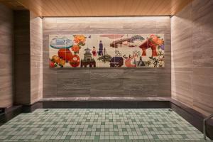 金泽金泽 穎特飯店的浴室铺有瓷砖地板,墙上挂有绘画作品
