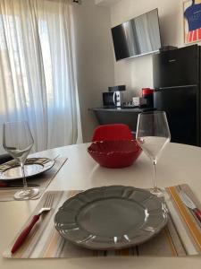 Nova MilaneseCasa Nova Luxury Apartment Suite Limoni的一张桌子,上面放有盘子和两杯酒杯