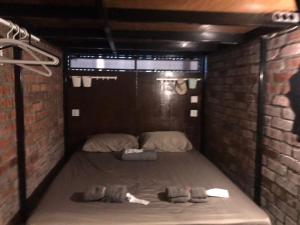 吉隆坡OA ThE FACTORY AT BUKIT BINTANG的小房间,砖墙里设有一张床铺
