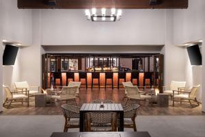 索尔万The Hadsten Solvang, Tapestry Collection by Hilton的大堂设有桌椅和酒吧。