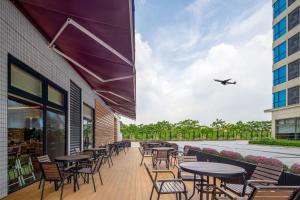 花都广州机场空港希尔顿花园酒店 的一个带桌椅的户外庭院和飞机