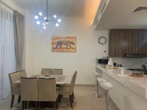 拉斯阿尔卡麦Villa Elena Hayat Island Marbella的厨房以及带桌椅的用餐室。