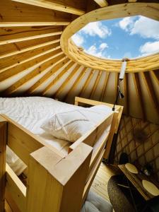 LedeackerMagnolia Hoeve - overnachten in de natuur op een paarden resort的圆窗客房内的一张木床