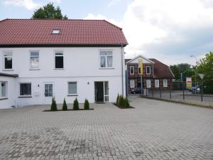 巴德贝芬森MOONROOMS Cityapartment 2 in Bad Bevensen的砖车道上一座白色房子,有红色屋顶