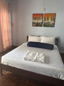 Ban KohongPiano Private House的一张带白色床单的床和两张毛巾