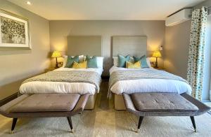 奥尔福德Grange Farm Park的一间卧室配有两张床和两张搁脚凳