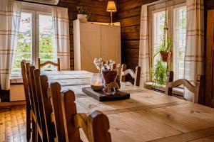 罗瓦涅米Kotatuli Forest Lodge的一间带木桌和窗户的用餐室