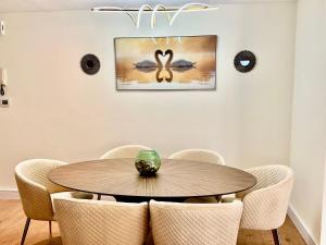 迪拜2BR Luxury Apartment Marina View的一间带木桌和椅子的用餐室