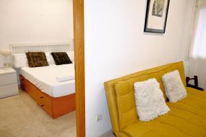 巴塞罗那Homenfun Barcelona Sagrada Familia Lepanto的一间卧室配有一张带镜子的床和一张黄色沙发