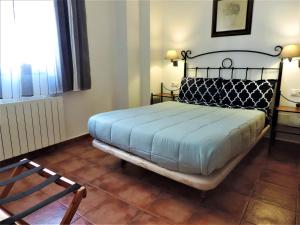 格拉纳达APARTAMENTOS CASERIA DE COMARES的卧室配有床、椅子和窗户。