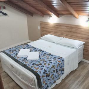 弗洛里亚诺波利斯豪拉酒店的一间卧室配有一张大床,上面有两个白色的板子