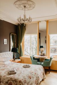 乌得勒支Boutique Hotel Museumkwartier的一间卧室配有一张床、椅子和吊灯