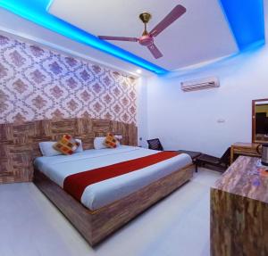 钱德加尔Rebirth Hotel的一间卧室配有一张带吊扇的床和一台电视。