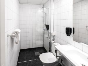 莫舍恩福如豪甘斯酒店的白色的浴室设有卫生间和淋浴。