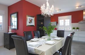 卡门港Beautiful Villa Ambar的一间带桌椅和红色墙壁的用餐室