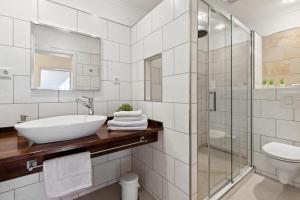 代德斯海姆Ferienwohnungen Deidesheim的白色的浴室设有水槽和淋浴。