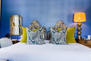 弗朗斯胡克La Fontaine Boutique Hotel by The Oyster Collection的蓝色卧室配有白色的床和枕头