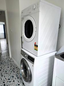 墨尔本PROMO!!! 2-Bedroom Home Near Airport, Train Station!的厨房配有洗衣机和烘干机。