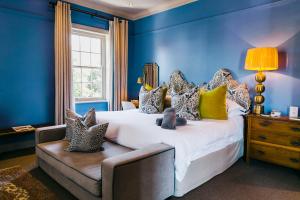 弗朗斯胡克La Fontaine Boutique Hotel by The Oyster Collection的蓝色的卧室设有一张大床和一个窗户