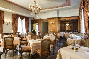 佛罗伦萨Adler Cavalieri Hotel-Private Spa & Gym的一间带桌椅和吊灯的餐厅