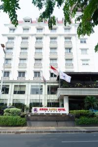 雅加达Arion Suites Hotel Kemang的前面有两面旗帜的白色建筑