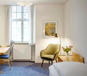 维堡帕拉兹酒店的一间卧室配有一张床、一把椅子和一张书桌