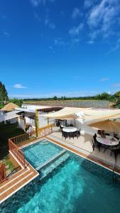 OtonUrban Glamp Resort的一个带桌子和遮阳伞的大型游泳池