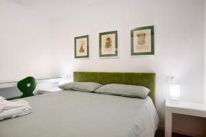 卡瓦莱塞La casa di Marco的卧室配有一张床,墙上有三幅照片