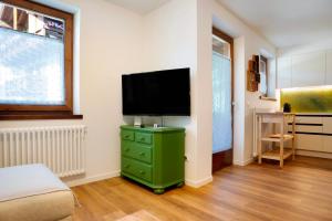 卡瓦莱塞La casa di Marco的一间卧室设有一台平面电视和绿色梳妆台